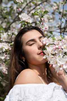 年轻的高加索人女人享受开花苹果树