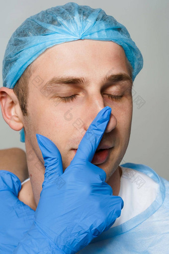 facebuilding鼻中隔成形术鼻子鼻整形术医生触摸男人。鼻子咨询检查塑料手术化妆品振兴面部治疗