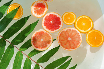 橙色柠檬葡萄柚水果水绿色叶子装饰聚会，派对柑橘类水果浴热夏天一天水果鸡尾酒