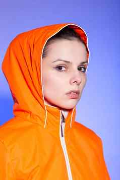 浅黑肤色的女人女人橙色夹克蓝色的背景