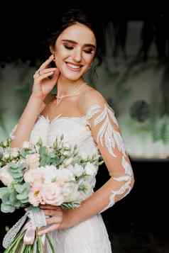 新娘婚礼花束微笑触摸脸头发女孩婚礼衣服时尚餐厅