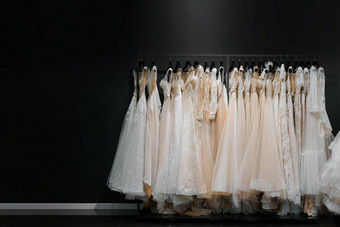 婚礼礼服使丝绸雪纺薄纱花边美丽的白色奶油新娘衣服衣架婚礼沙龙照片空空间左一边文本做广告