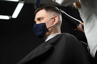 理发店服务冠状病毒科维德期干燥头发切割理发店英俊的男人。面具