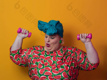 脂肪女人节食健身健康首页大女人体育运动健康的健身体育概念大<strong>小年</strong>轻的女人锻炼哑铃黄色的背景