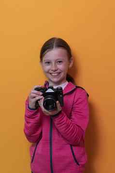 女孩摄影师孤立的黄色的背景微笑采取照片复古的古董相机