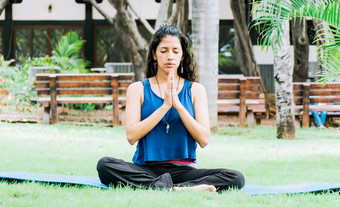 女孩坐着冥想瑜伽在户外女人瑜伽在户外年轻的女人瑜伽关闭眼睛