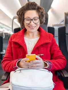 微笑女人红色的露营装备外套发短信智能手机郊区火车旅行土地车辆