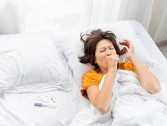 生病的女人咳嗽床上温度计药片白色床上亚麻早....首页冠状病毒科维德检疫隔离首页