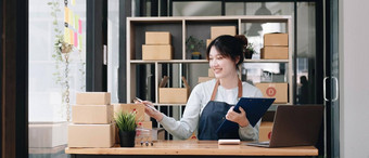 肖像年轻的亚洲女人电子商务员工坐着办公室完整的包背景写请注意订单计算器锻造业务电子商务交付业务