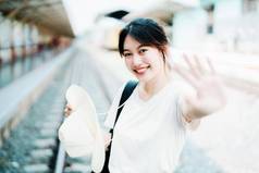 夏天放松假期旅行肖像可爱的亚洲女孩显示微笑显示快乐等待火车站夏天旅行