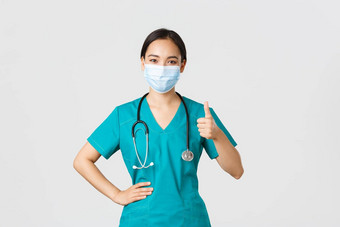 科维德冠状病毒疾病医疗保健工人概念自信微笑亚洲医生女护士医生医疗面具实习医生风云显示竖起大拇指保证质量guanratee服务