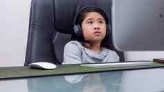 亚洲女孩研究在线笔记本电脑孩子穿耳机打字键盘笔记本学习互联网教训检疫学生学习互联网在线类学校新冠病毒
