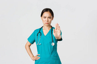 科维德医疗保健工人流感大流行概念愤怒的严肃的表情亚洲医生女医生护士实习医生风云皱着眉头不高兴扩展手显示停止不同意禁止禁止