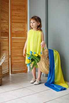 乌克兰女孩黄色的衣服持有袋黄色的蓝色的郁金香