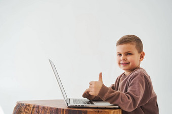 孩子男孩研究在线移动PC显示拇指微笑在线教育电子学习孩子采取在线课程移动PC