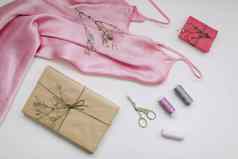 作文粉红色的丝绸织物礼物工艺纸线程剪刀白色背景平躺前视图爱好休闲概念