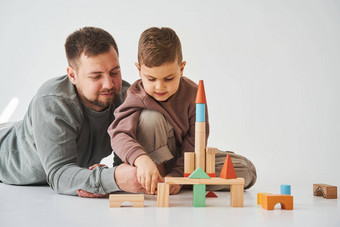 亲子鉴定儿子爸爸玩彩色的砖玩具白色背景父亲需要护理孩子