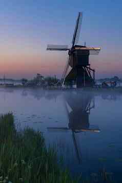 传统的荷兰风车色彩鲜艳的天空日出小孩堤防荷兰