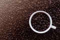 咖啡杯烤豆子咖啡豆子背景前视图复制空间前视图咖啡豆子背景白色咖啡杯