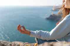 瑜伽手势健康的生活方式概念手冥想瑜珈女人显示吉安穆德拉海日落背景
