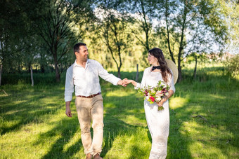 快乐年轻的人<strong>婚礼服</strong>装走草地