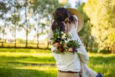 时尚的快乐新娘新郎持有选手跳舞新郎提高了旋转新娘新婚夫妇接吻背景自然院子里房子关闭婚礼跳舞