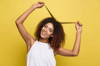 美丽的有吸引力的非洲美国女人<strong>发布</strong>玩卷曲的非洲式发型头发黄色的工作室<strong>背景</strong>复制空间