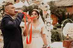 新婚夫妇喝香槟眼镜红色的丝带系