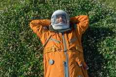 快乐宇航员穿头盔太阳镜空间西装休息户外