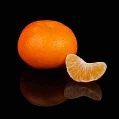 片成熟的橘子橘子黑色的背景反射