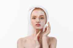 美丽的模型应用化妆品奶油治疗脸白色