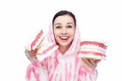 快乐女人粉红色的运动衫持有牙科实物模型下巴手