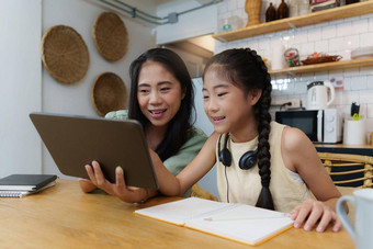 自主学习亚洲妈妈。年轻的女孩学生学习在线类电子学习在线教育概念