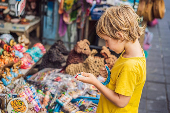 男孩市场乌布巴厘岛典型的纪念品商店销售记忆手工艺品巴厘岛著名的乌布市场印尼巴厘岛的市场记忆木工艺品当地的居民旅行孩子们概念孩子们友好的的地方