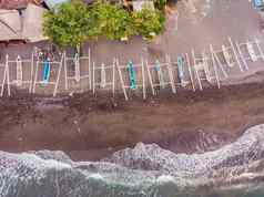 空中视图艾湄湾海滩巴厘岛印尼传统的钓鱼船被称为jukung黑色的沙子海滩山伟大的火山背景部分覆盖云