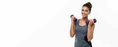 健康的健身概念美丽的美国非洲夫人健身衣服锻炼哑铃孤立的白色背景