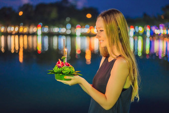 女旅游持有阿来水灯手发射水阿来水灯节日人买花蜡烛光浮动水庆祝阿来水灯节日泰国