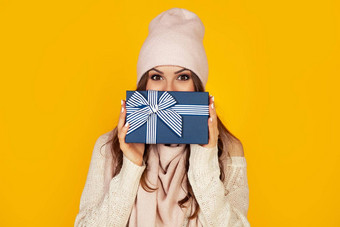 快乐年轻的女人礼物盒子手涵盖了一半脸一年的礼物女孩显示礼物相机概念礼物惊喜一年圣诞节