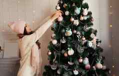 快乐年轻的女人装修圣诞节树挂球树圣诞节装饰玩具挂树圣诞节树球一年圣诞节假期概念