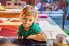情感男孩表格咖啡馆可爱的男孩坐着户外餐厅夏天一天孩子咖啡馆等待订单