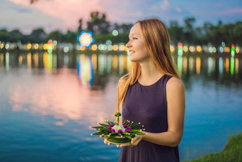 女旅游持有阿来水灯手发射水阿来水灯节日人买花蜡烛光浮动水庆祝阿来水灯节日泰国