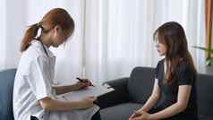 女医生咨询年轻的病人填充形式咨询