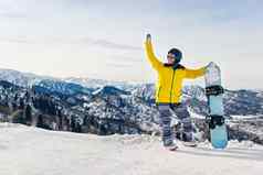 年轻的女人滑雪黄色的夹克黑色的头盔背景雪山