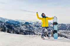 年轻的女人滑雪黄色的夹克黑色的头盔背景雪山