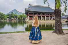 年轻的高加索人女旅游韩服国家朝鲜文衣服朝鲜文宫旅行韩国概念国家朝鲜文服装娱乐游客国家朝鲜文服装