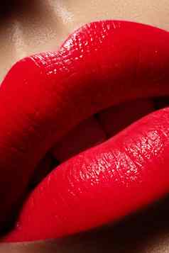 美丽的女嘴唇甜蜜的吻红色的口红唇化妆宏拍摄热时尚唇化妆