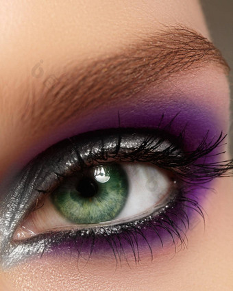 特写镜头女眼睛时尚明亮的化妆美丽的银紫色的眼影闪闪发光的黑色的眼线笔