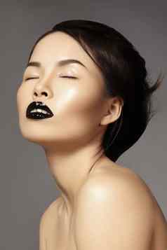 完美的亚洲模型时尚化妆发型美万圣节风格黑色的嘴唇化妆走猫步脸