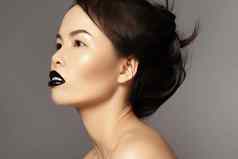 完美的亚洲模型时尚化妆发型美万圣节风格黑色的嘴唇化妆走猫步脸
