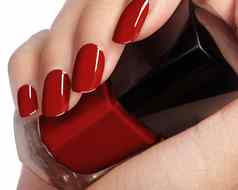 美丽的女手指理想的闪亮的红色的修指甲持有指甲波兰的瓶护理女手明亮的过来这里